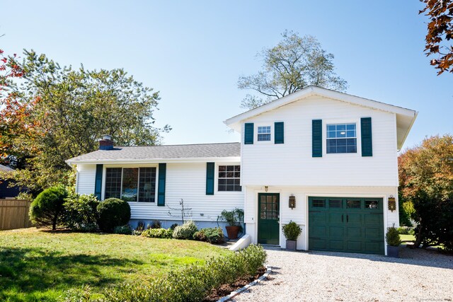 tri-level home featuring a front yard and a garage