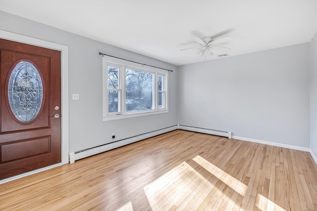 entryway featuring ceiling fan, light hardwood / wood-style floors, and a baseboard heating unit