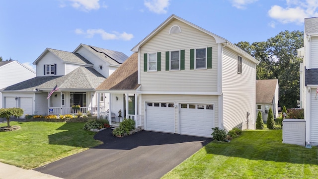 view of front of property with a front yard, a porch, and a garage