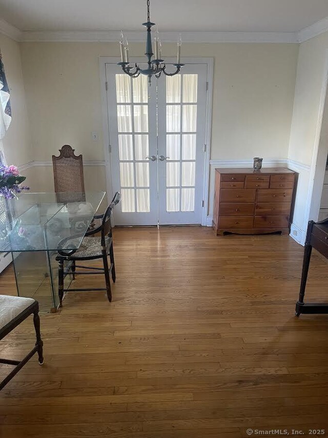 191 Anson St, Stratford, CT 06614 - unfurnished dining area featuring wood-type flooring, an inviting chandelier, and crown molding