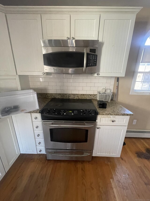 191 Anson St, Stratford, CT 06614 - kitchen featuring appliances with stainless steel finishes, baseboard heating, white cabinets, and dark wood-type flooring