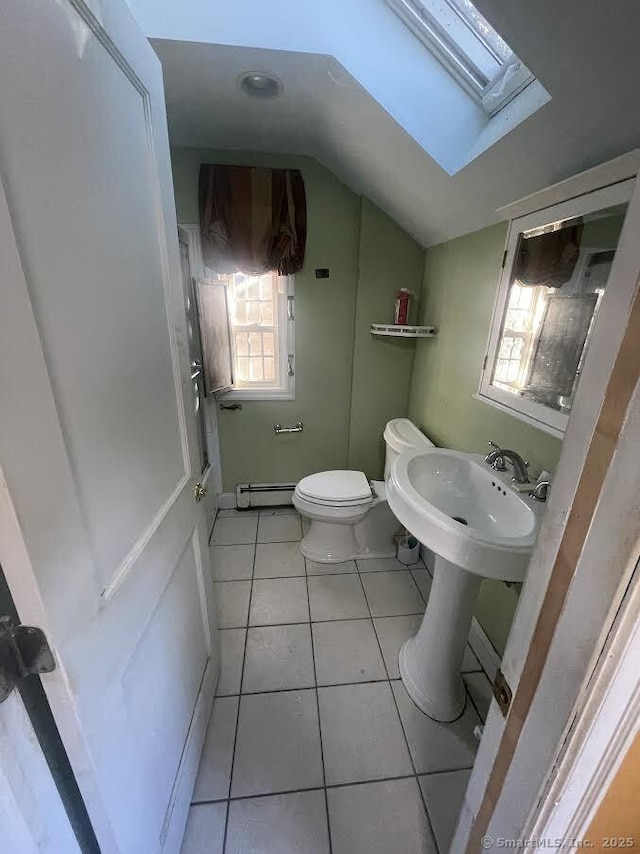 191 Anson St, Stratford, CT 06614 - bathroom featuring baseboard heating, toilet, tile patterned floors, lofted ceiling with skylight, and sink
