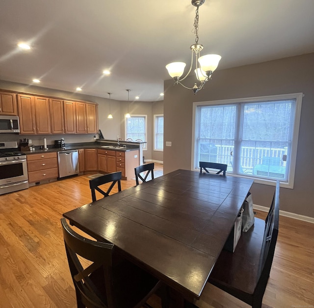 dining room featuring light hardwood / wood-style flooring, a chandelier, and sink