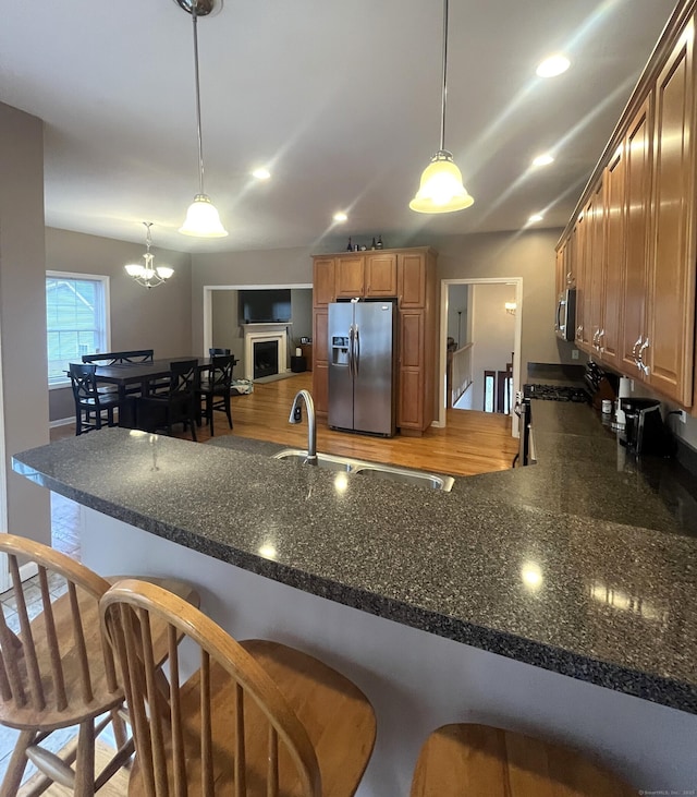 kitchen featuring a kitchen bar, decorative light fixtures, and stainless steel appliances