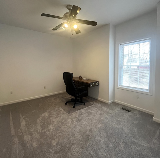 unfurnished office with ceiling fan and dark carpet