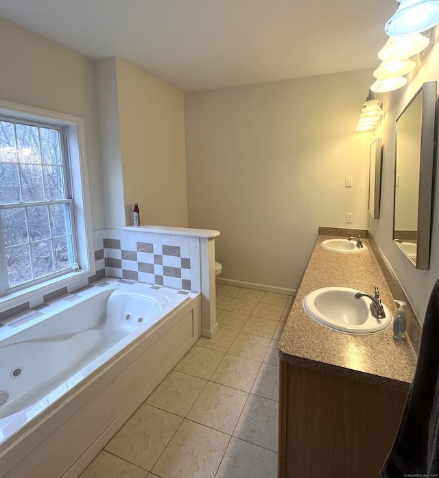 bathroom with tile patterned floors, vanity, toilet, and a tub