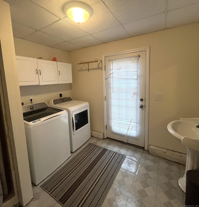 clothes washing area featuring cabinets and independent washer and dryer