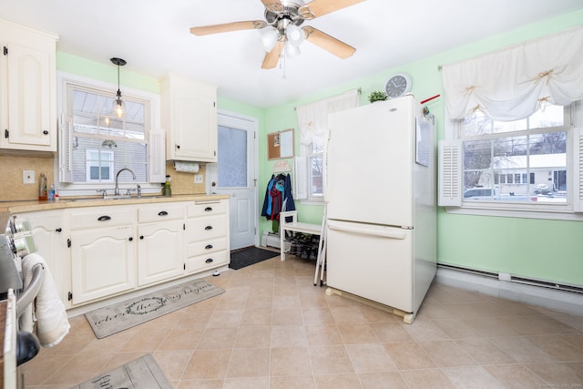 kitchen with pendant lighting, white cabinetry, white refrigerator, backsplash, and ceiling fan