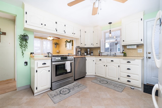 kitchen with white cabinetry, ceiling fan, appliances with stainless steel finishes, pendant lighting, and sink