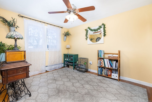 misc room featuring ceiling fan, a baseboard heating unit, and light hardwood / wood-style flooring