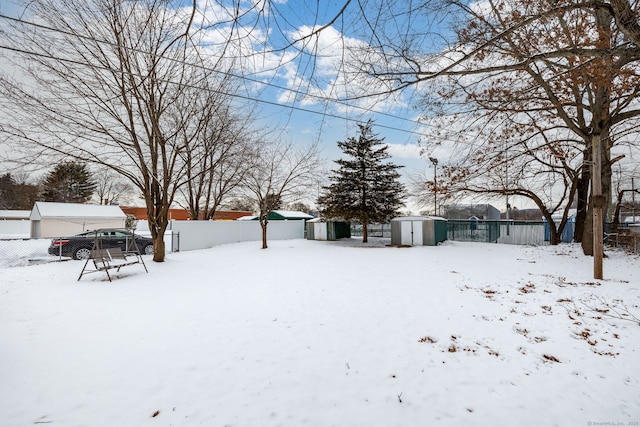 yard layered in snow featuring a shed