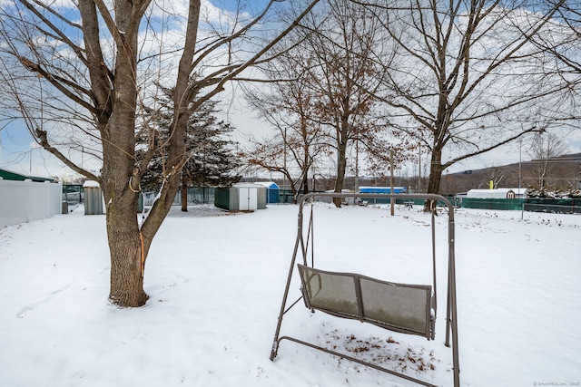 yard layered in snow featuring a storage shed