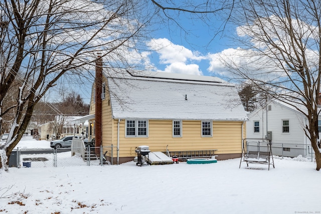 view of snow covered rear of property