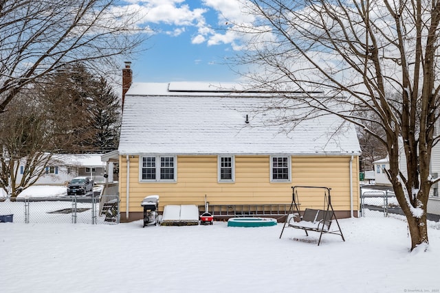 view of snow covered back of property