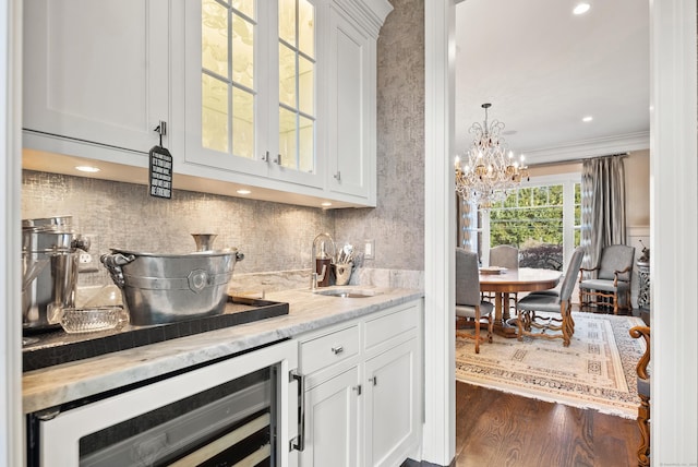 kitchen with glass insert cabinets, beverage cooler, and white cabinetry