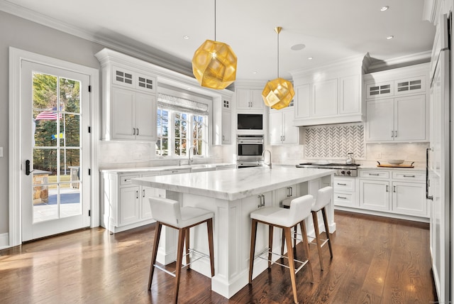 kitchen featuring pendant lighting, glass insert cabinets, and white cabinets