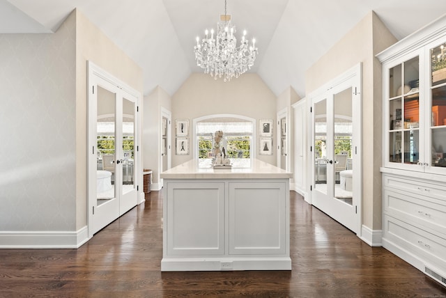 interior space featuring french doors, light countertops, hanging light fixtures, glass insert cabinets, and white cabinets