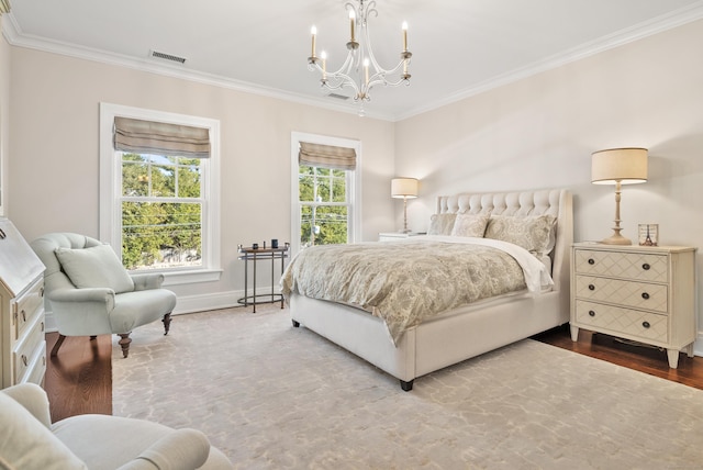 bedroom featuring wood finished floors, visible vents, baseboards, ornamental molding, and an inviting chandelier