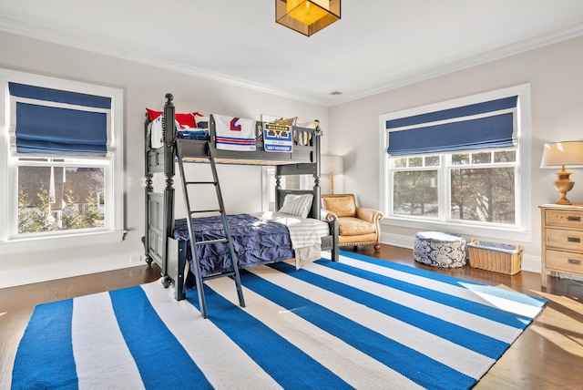 bedroom with ornamental molding, dark wood finished floors, and baseboards