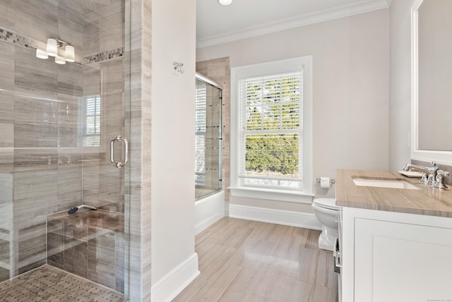 bathroom featuring toilet, vanity, baseboards, ornamental molding, and a shower with door