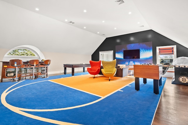 game room featuring plenty of natural light, visible vents, vaulted ceiling, and wood finished floors