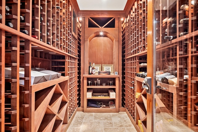 wine cellar featuring stone finish floor and crown molding