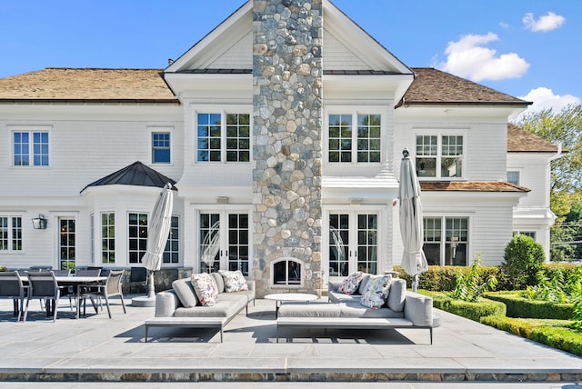 rear view of house featuring a patio area, french doors, outdoor lounge area, and a chimney