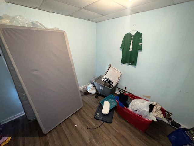 unfurnished bedroom with dark hardwood / wood-style flooring and a drop ceiling