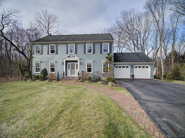 colonial inspired home featuring a front yard and a garage