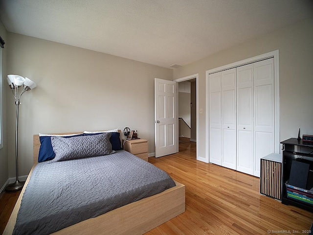 bedroom with a closet and hardwood / wood-style floors