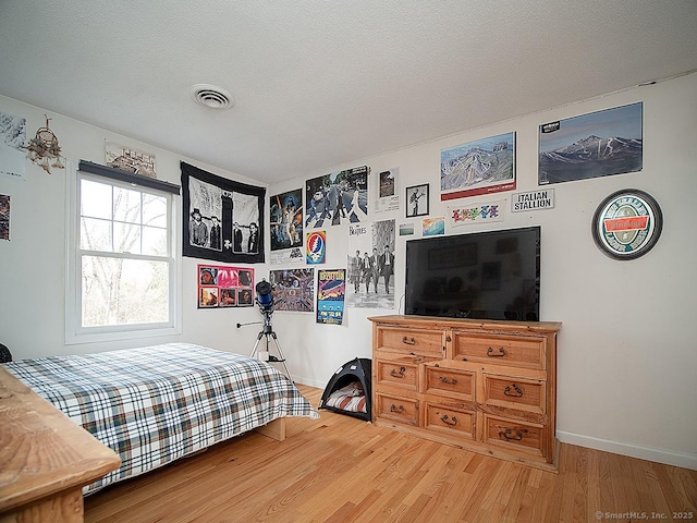 bedroom with wood-type flooring and a textured ceiling