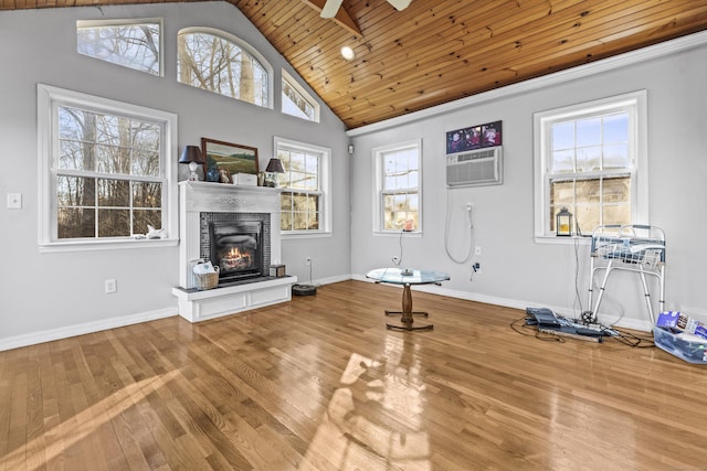 interior space with ceiling fan, wood ceiling, plenty of natural light, and an AC wall unit