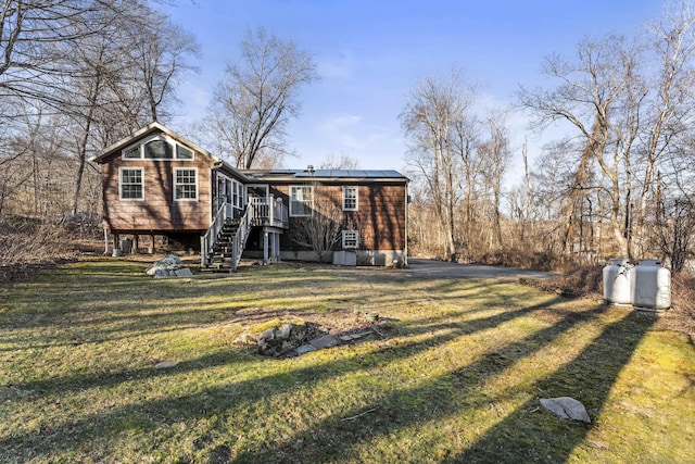 back of property with a deck, a lawn, and solar panels