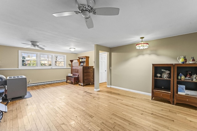 living area featuring ceiling fan, light hardwood / wood-style flooring, and a baseboard radiator