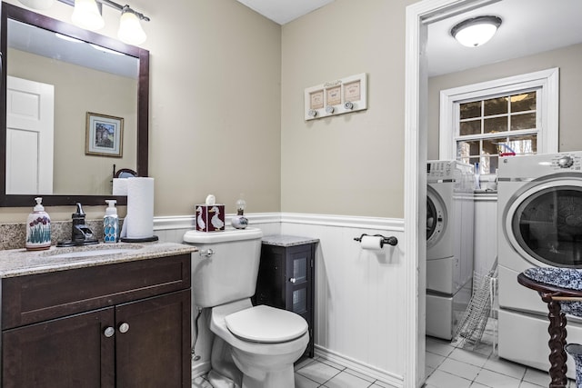 full bathroom featuring separate washer and dryer, tile patterned floors, vanity, toilet, and shower / bath combo