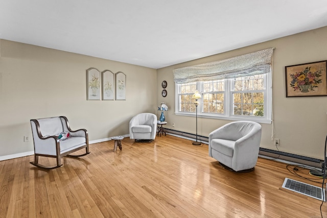 living area with baseboard heating and wood-type flooring