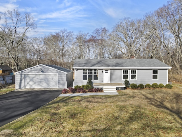 ranch-style house with a garage, a front yard, and an outbuilding