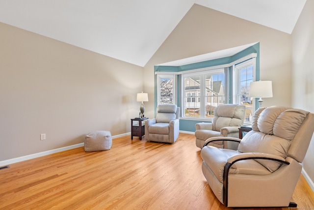 sitting room featuring light wood-type flooring and high vaulted ceiling