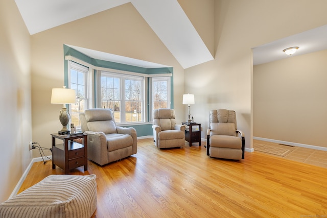 sitting room with light hardwood / wood-style floors and lofted ceiling