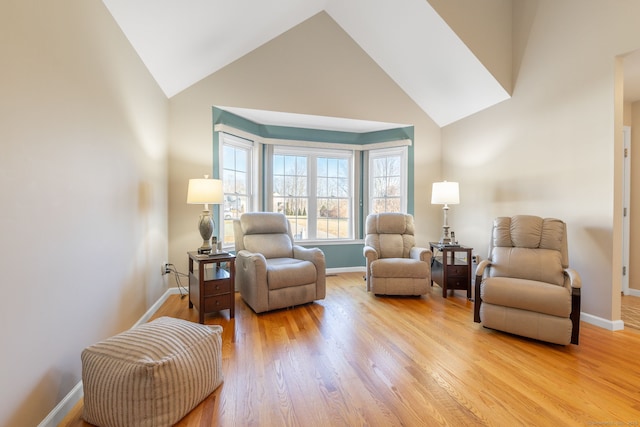 sitting room with vaulted ceiling and light wood-type flooring