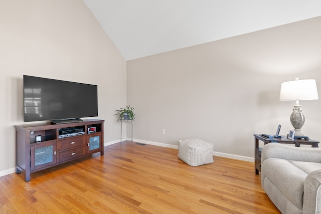 living room featuring light hardwood / wood-style floors and lofted ceiling