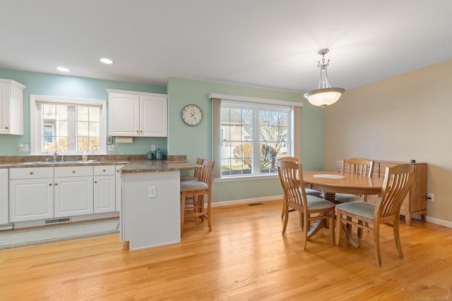 dining space with light wood-type flooring and sink