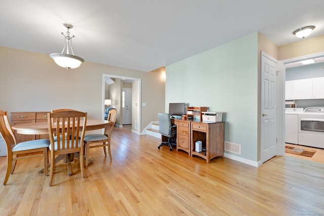 dining space with washing machine and clothes dryer and light hardwood / wood-style flooring