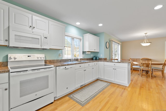 kitchen featuring white appliances, a healthy amount of sunlight, sink, pendant lighting, and white cabinetry