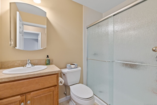 bathroom with vanity, toilet, and a shower with door