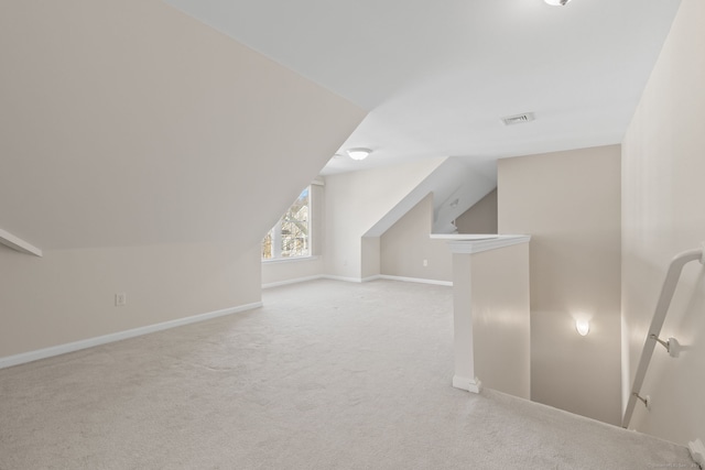 additional living space with light colored carpet and lofted ceiling