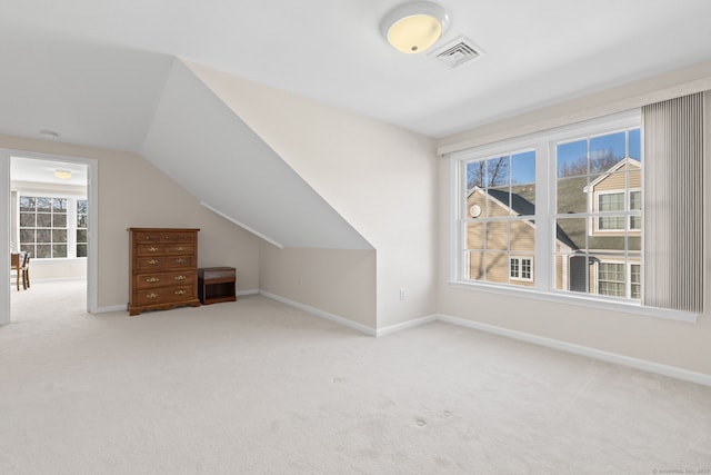 bonus room with light colored carpet and lofted ceiling