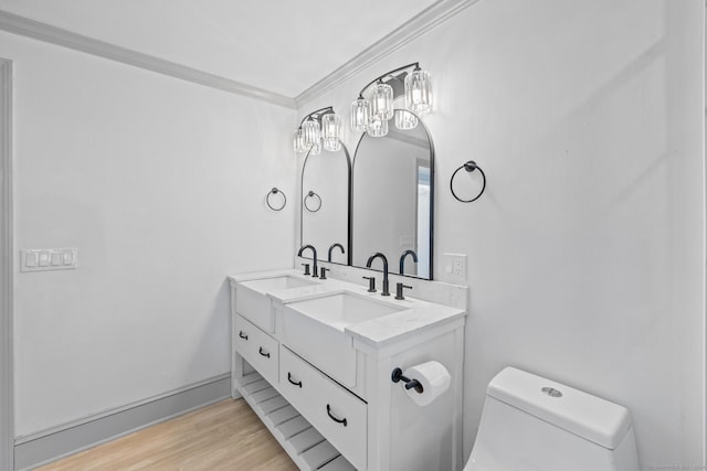 bathroom with toilet, vanity, ornamental molding, and hardwood / wood-style floors