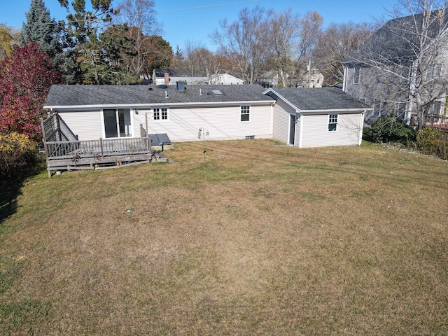 rear view of property featuring a deck and a yard