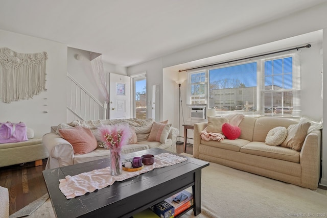 living room featuring cooling unit, light hardwood / wood-style floors, and baseboard heating